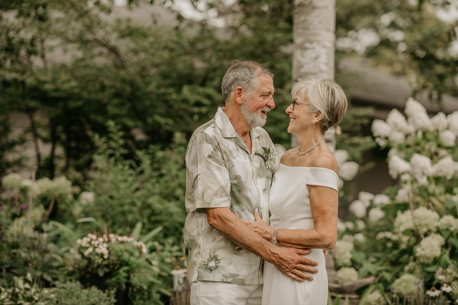 A man and a woman are standing next to each other in a garden.