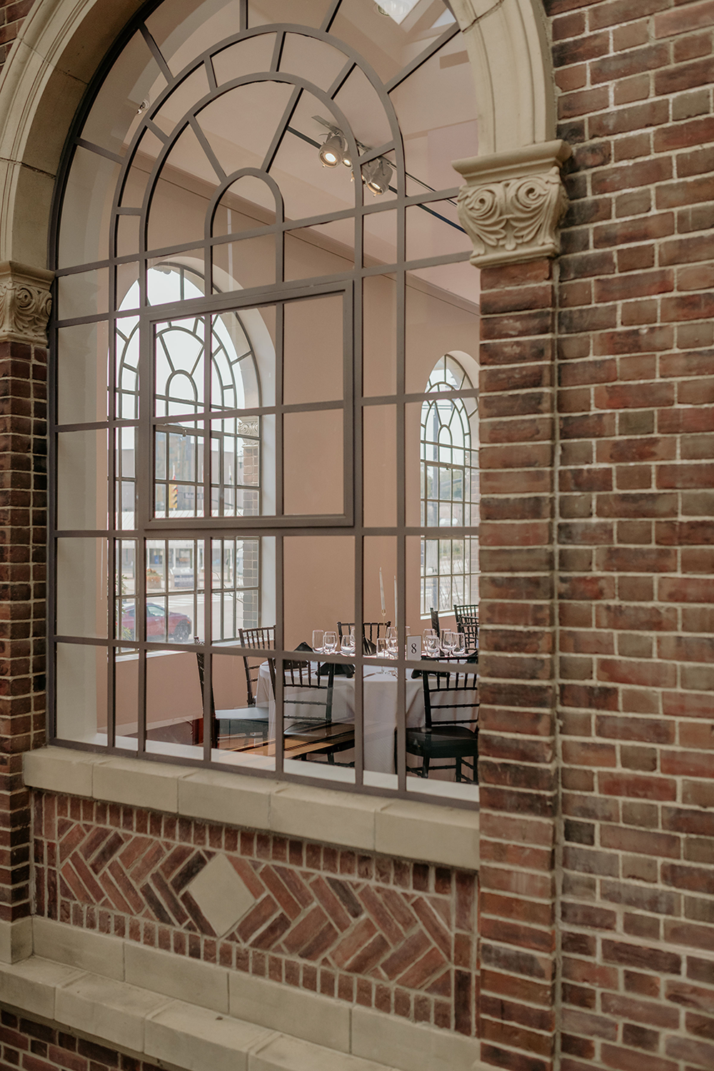 A brick building with a large window looking out to a dining room.
