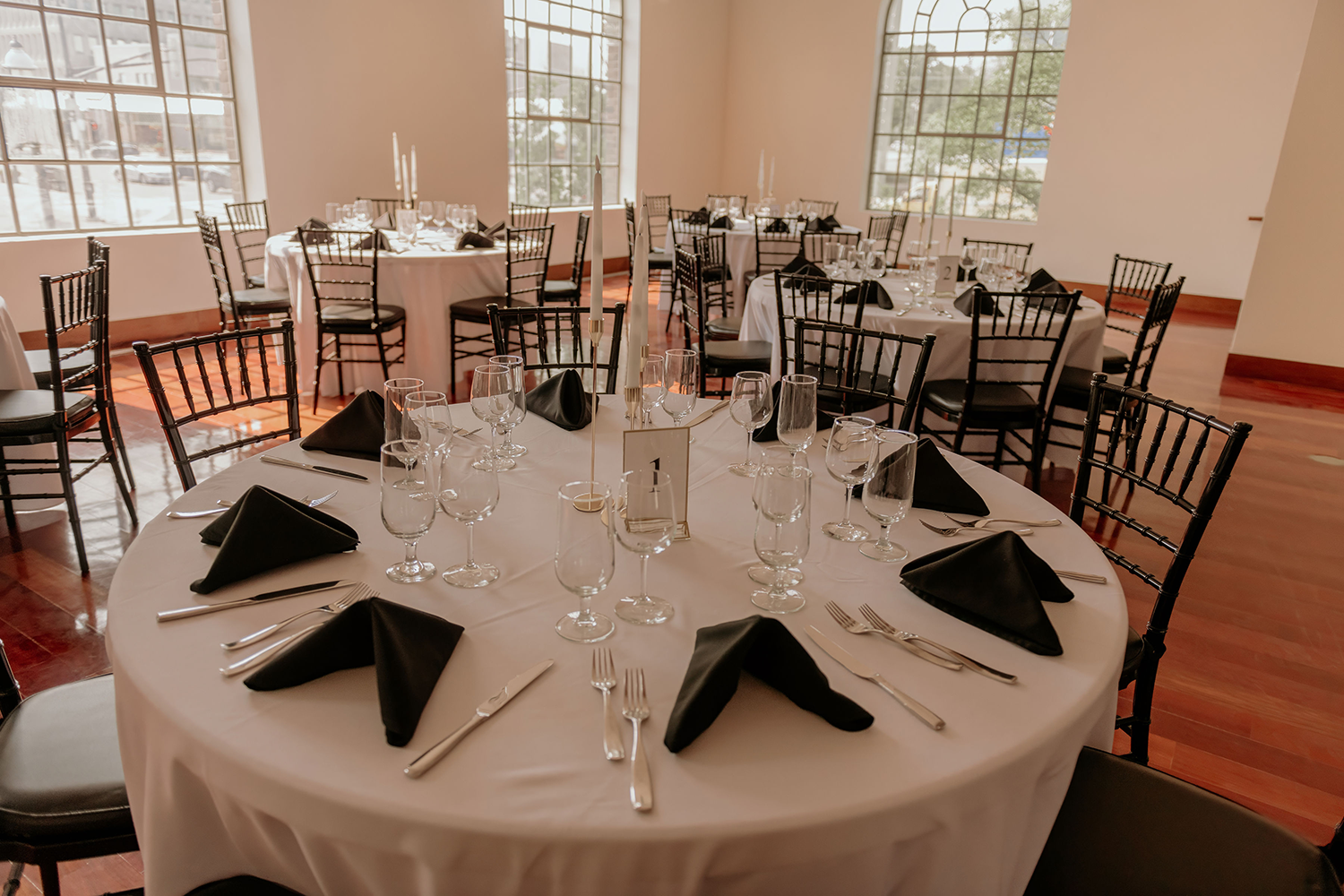A large room with tables and chairs set up for a wedding reception.