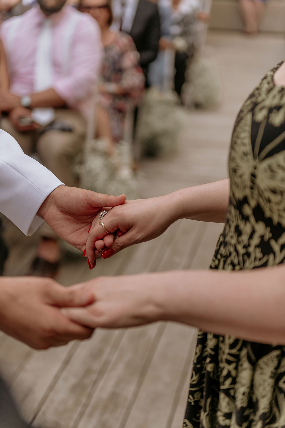 A bride and groom are holding hands during their wedding ceremony.