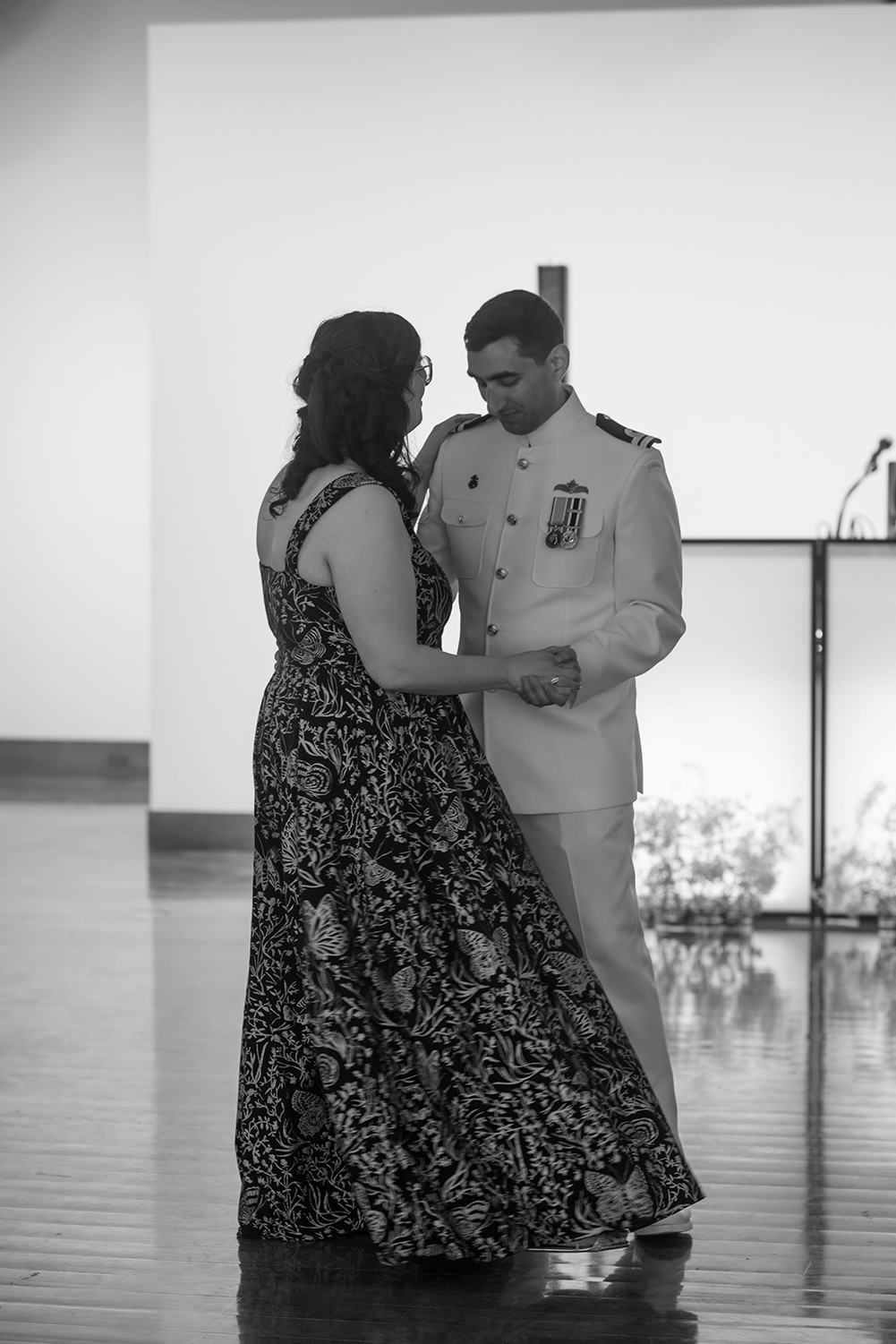 A man and a woman are dancing together in a black and white photo.