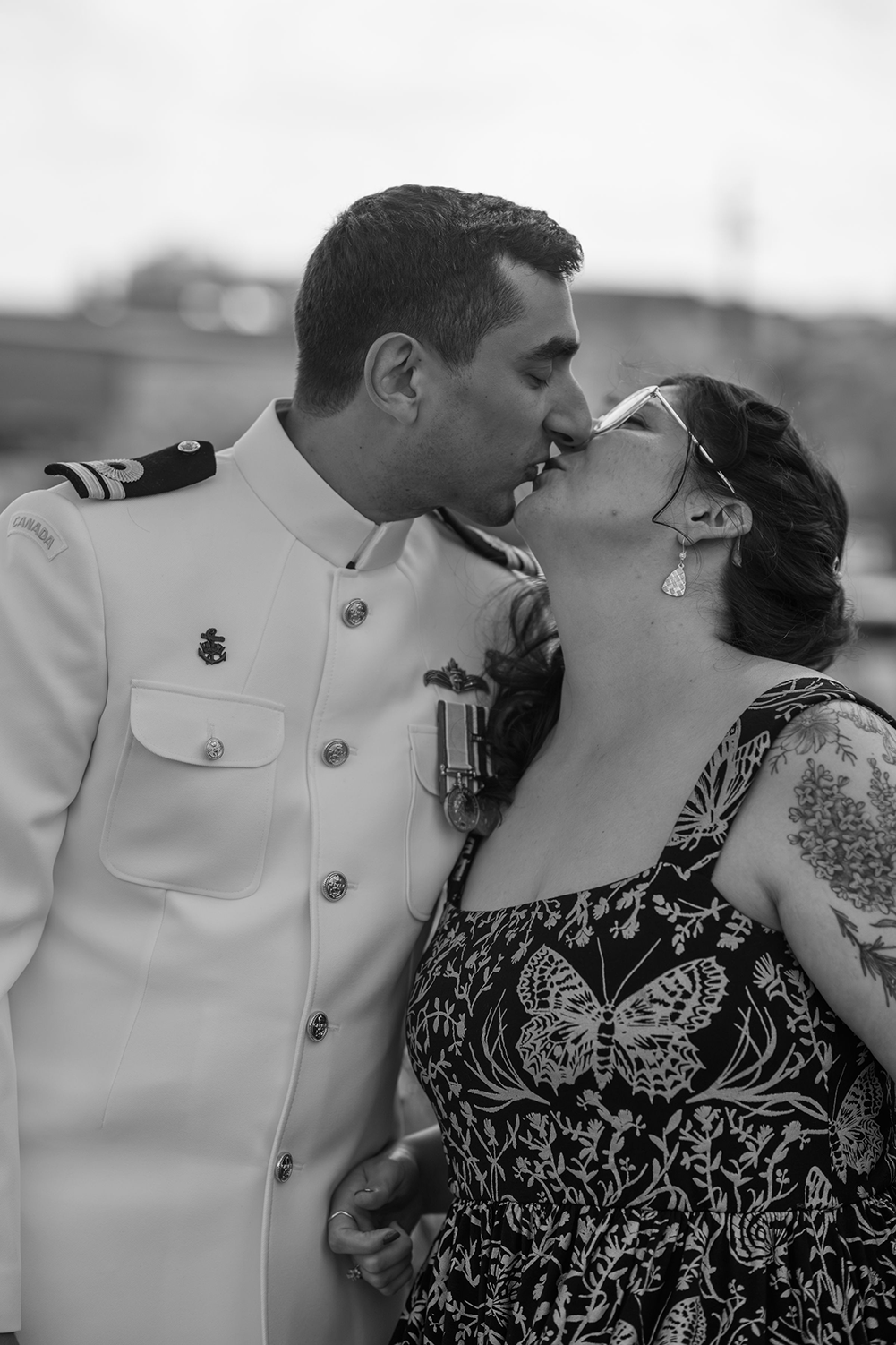 A man in a military uniform is kissing a woman in a black and white photo.