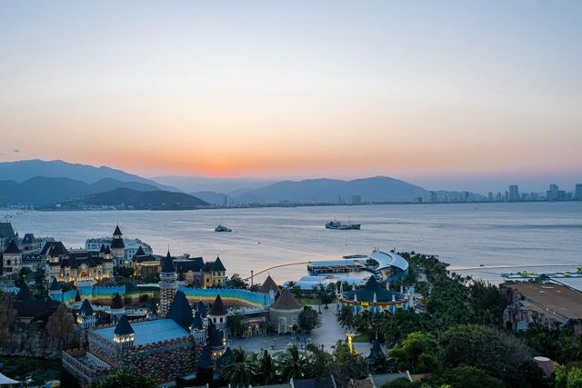 An aerial view of a city next to a body of water at sunset.