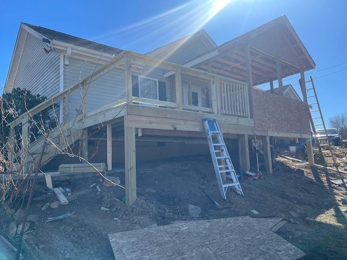 A house is being built on stilts with a deck and stairs.