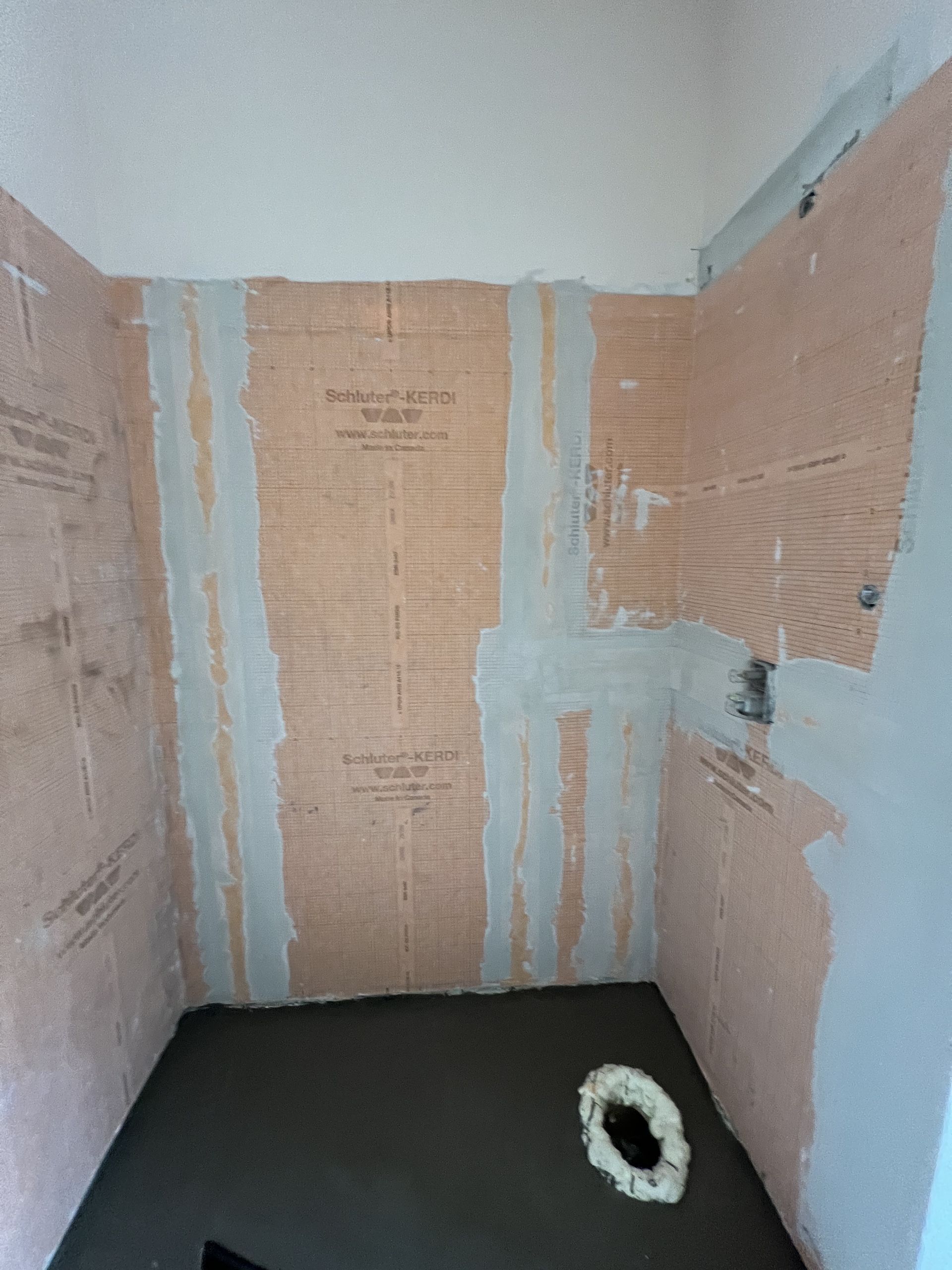 A bathroom with a toilet in it and a hole in the floor.