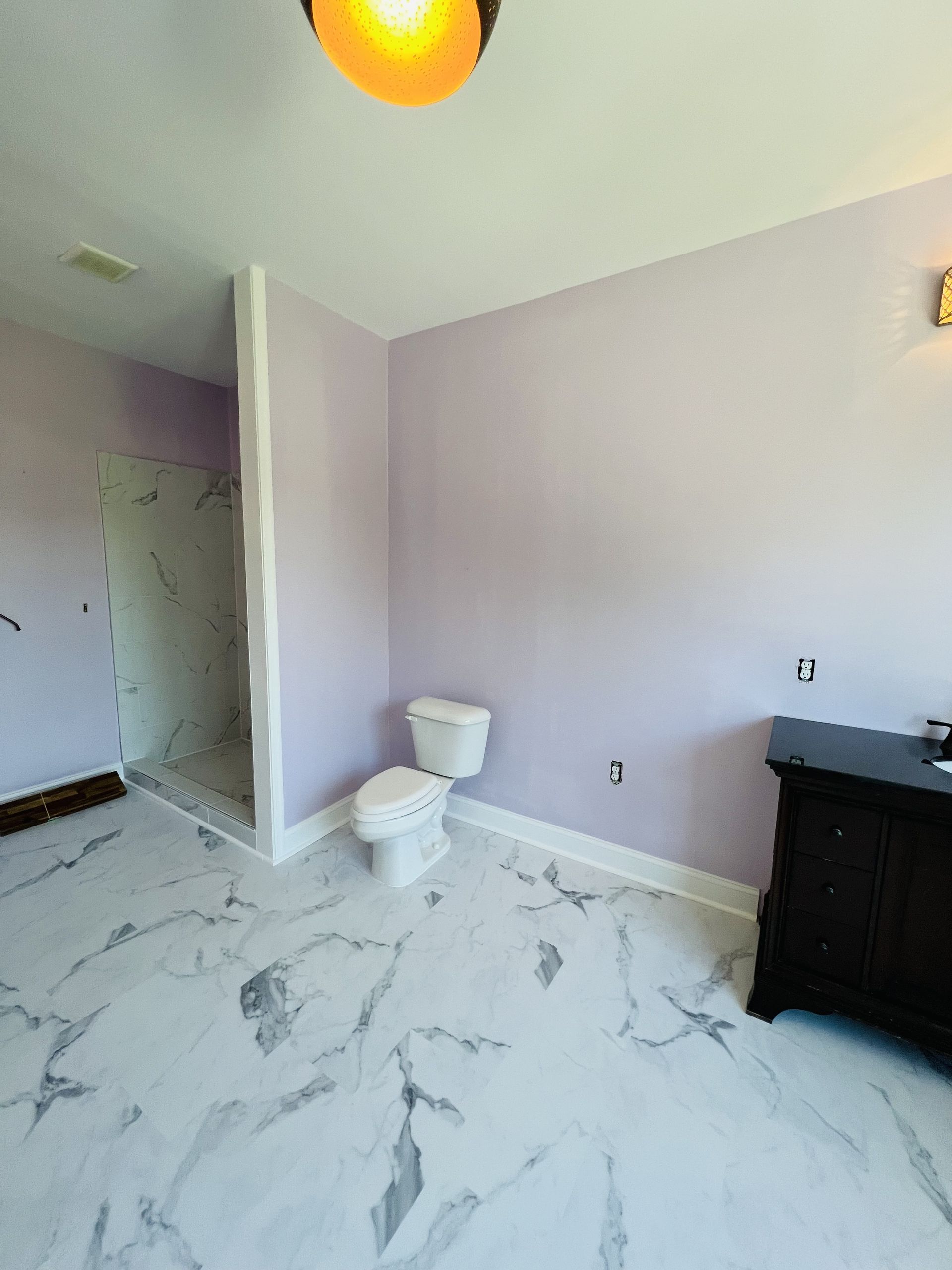 A bathroom with a toilet and a marble floor
