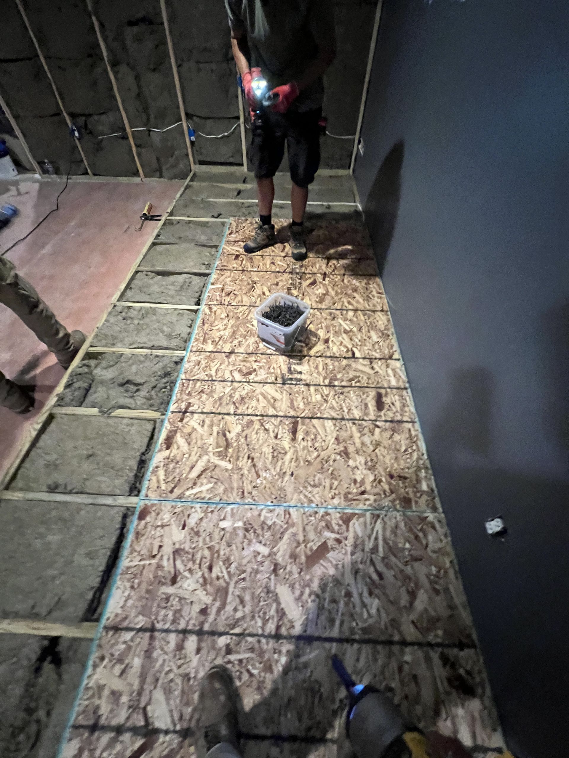 A man is standing on a wooden floor in a room.