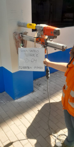 Una persona está usando una máquina para cortar un agujero en una pared.