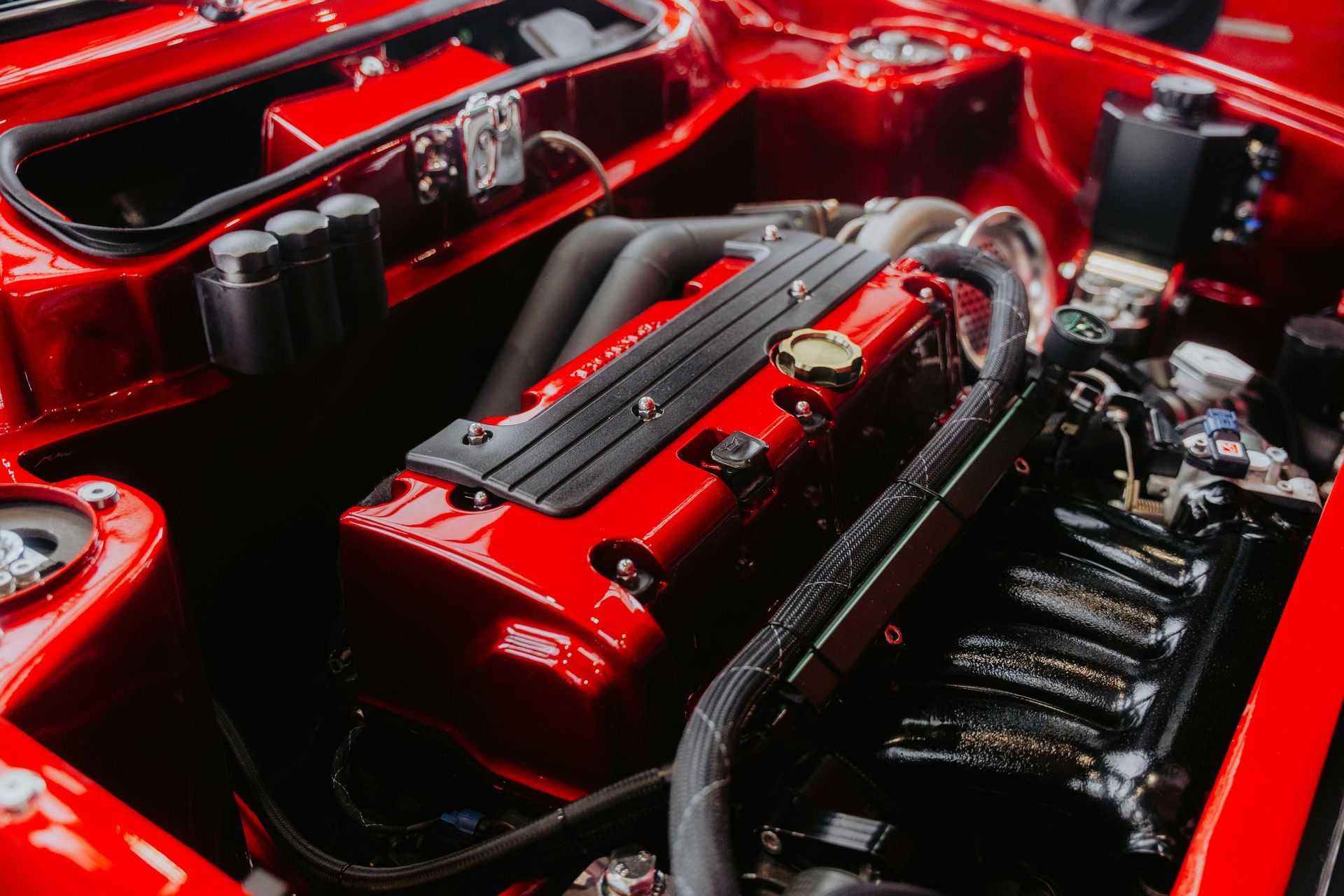 Red engine bay with a red engine block and headers.