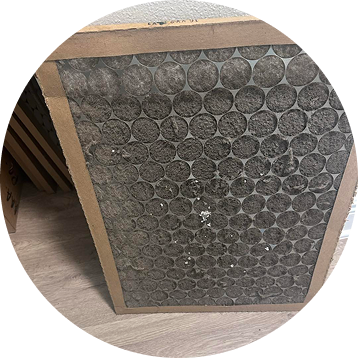 Dirty air filter, rectangular, gray, with a cardboard frame.