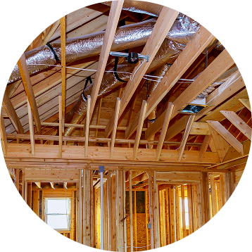 Interior view of a building under construction, showing wooden framing and ductwork.