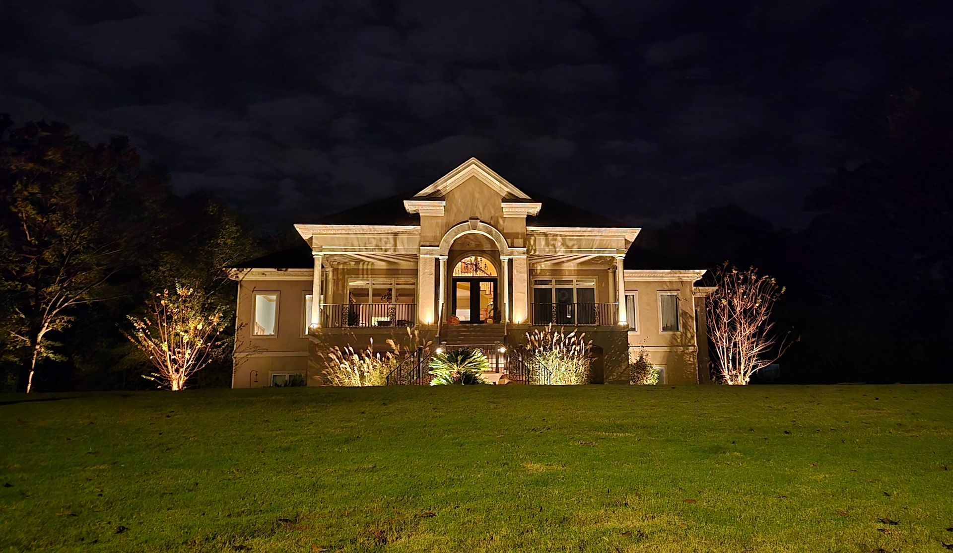 Solar lights illuminate a gravel and grassy garden bed.