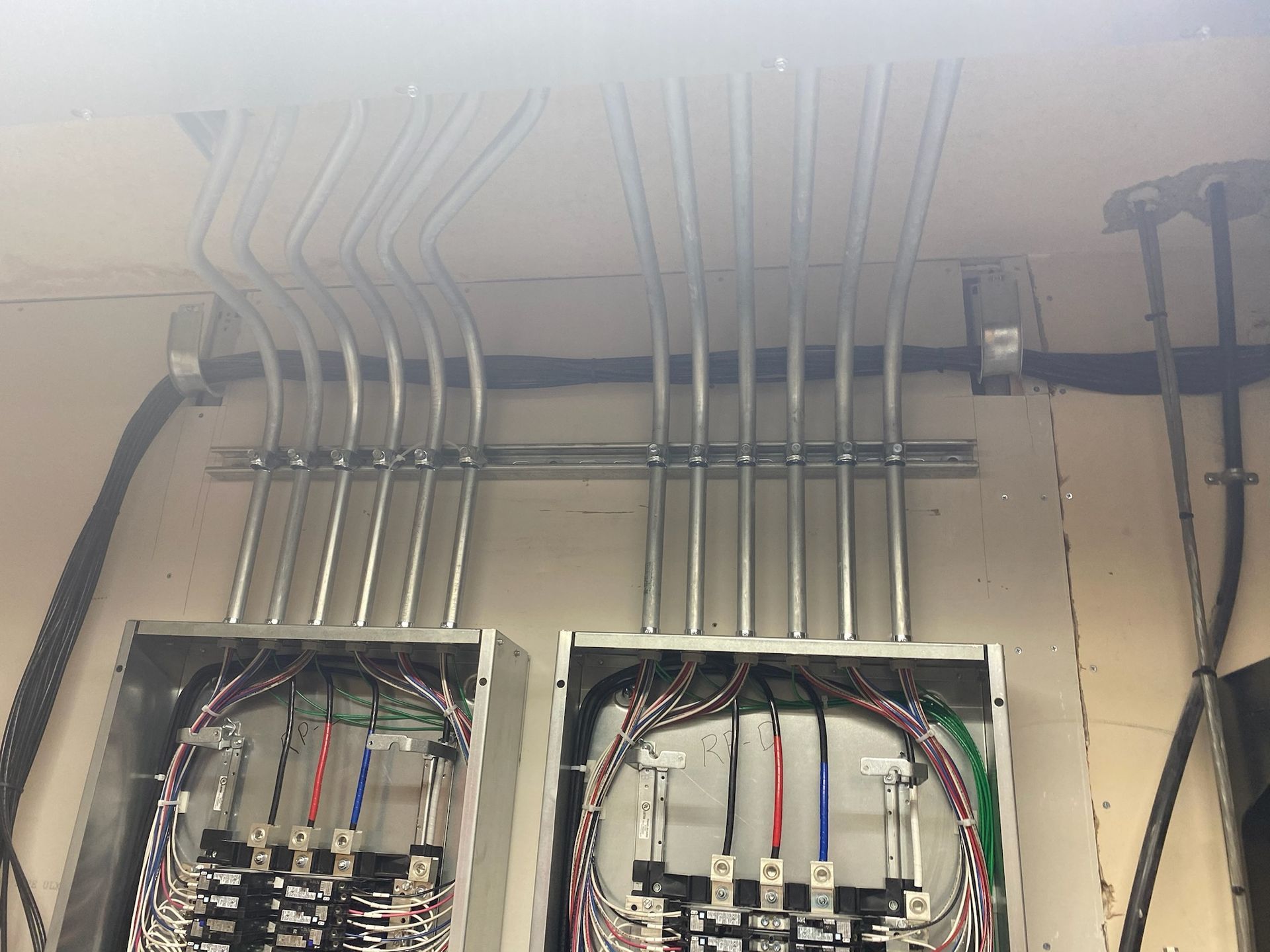 A bunch of wires are hanging from the ceiling of a building.