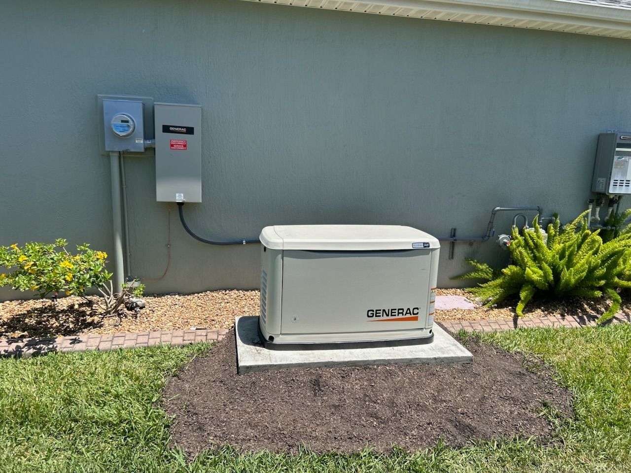 A generator is sitting in the grass in front of a house.