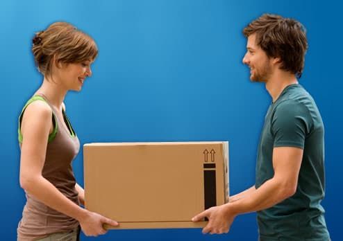 two people carrying a box for storage