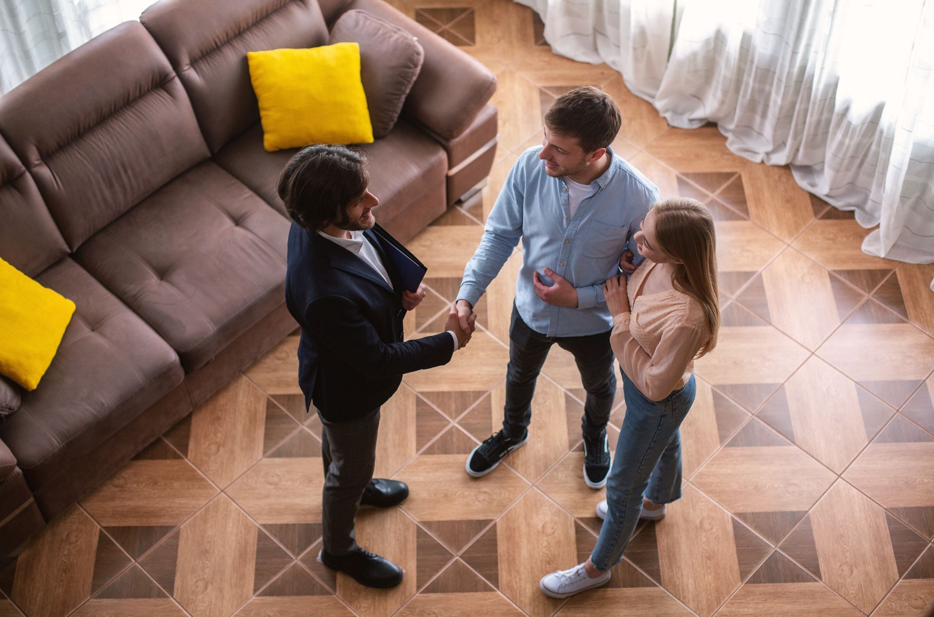 Couple views real estate that has been staged with furniture