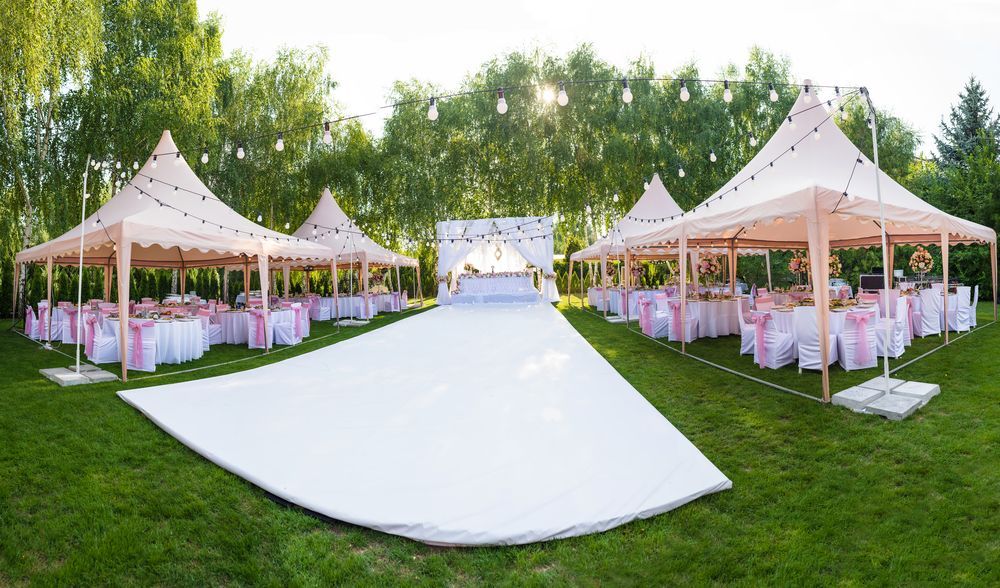 A Row of Marquees With Tables and Chairs Set up For a Wedding Reception — Event Hire in Wodonga, NSW