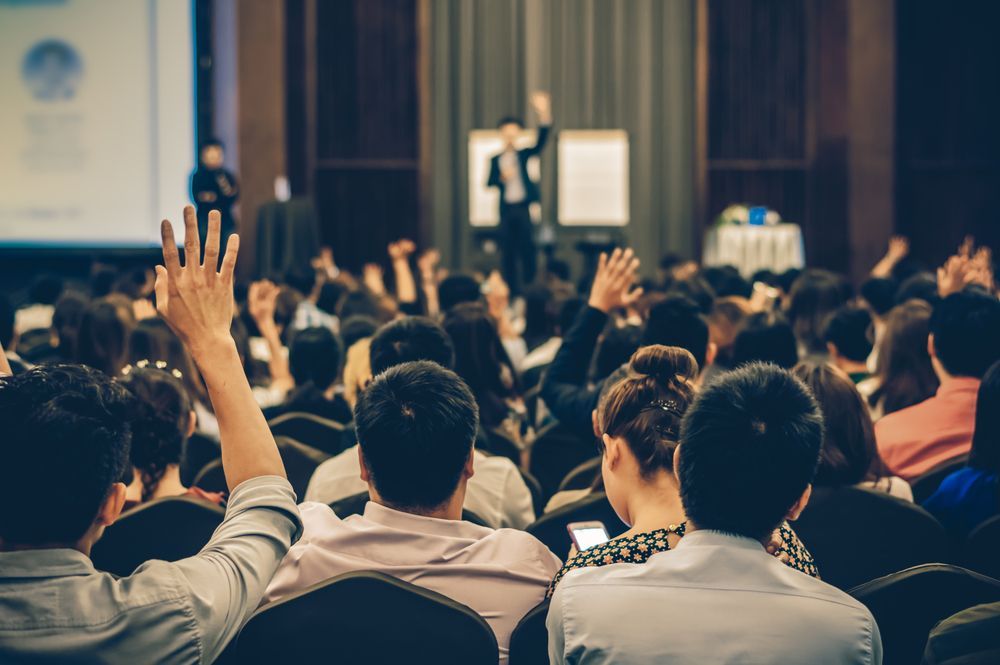 A Crowd of People in Conference are Raising Their Hands — Event Hire in Wodonga, NSW