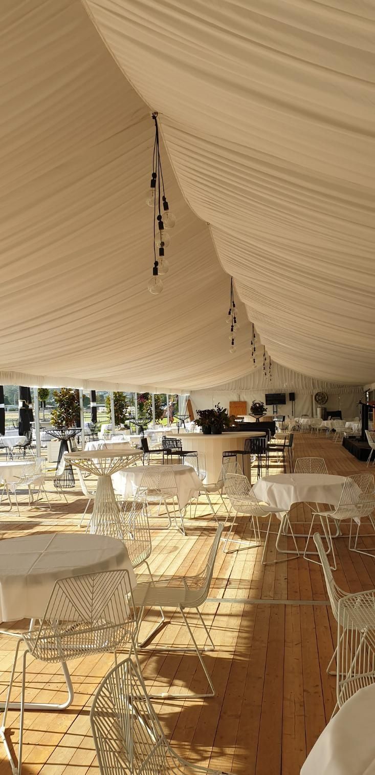 A Large Marquee With Tables and Chairs Underneath It — Event Hire in Wodonga, NSW