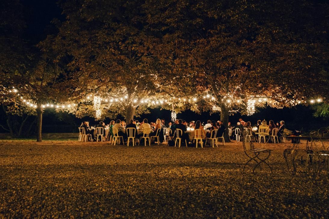 A Group of People are Sitting at Tables Under a String of Lights — Event Hire in Albury, NSW