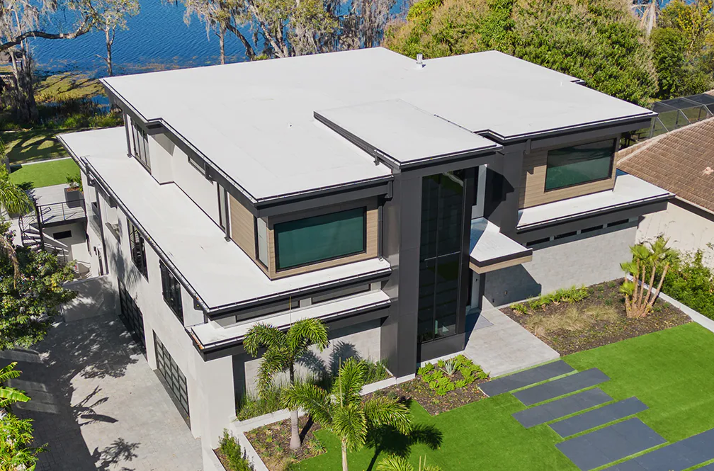 Modern two-story house with white roof, gray exterior, and landscaped front yard