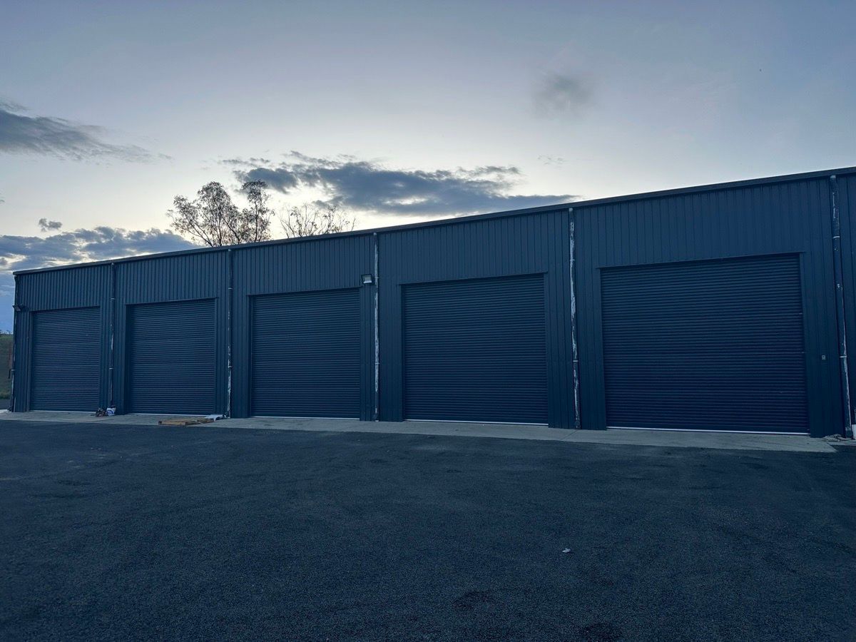 A garage door is sitting on the side of a brick building.