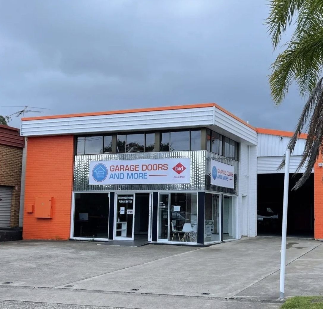 An orange building with a sign that says garage doors and more