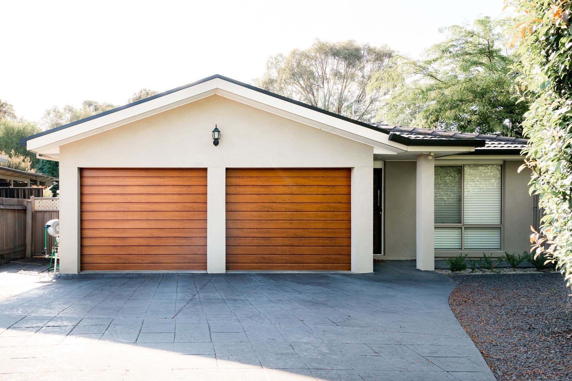 A white house with two wooden garage doors