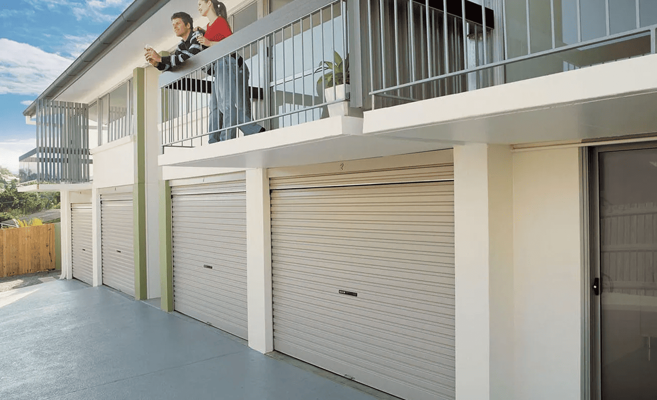 A couple of people standing on a balcony of a building.