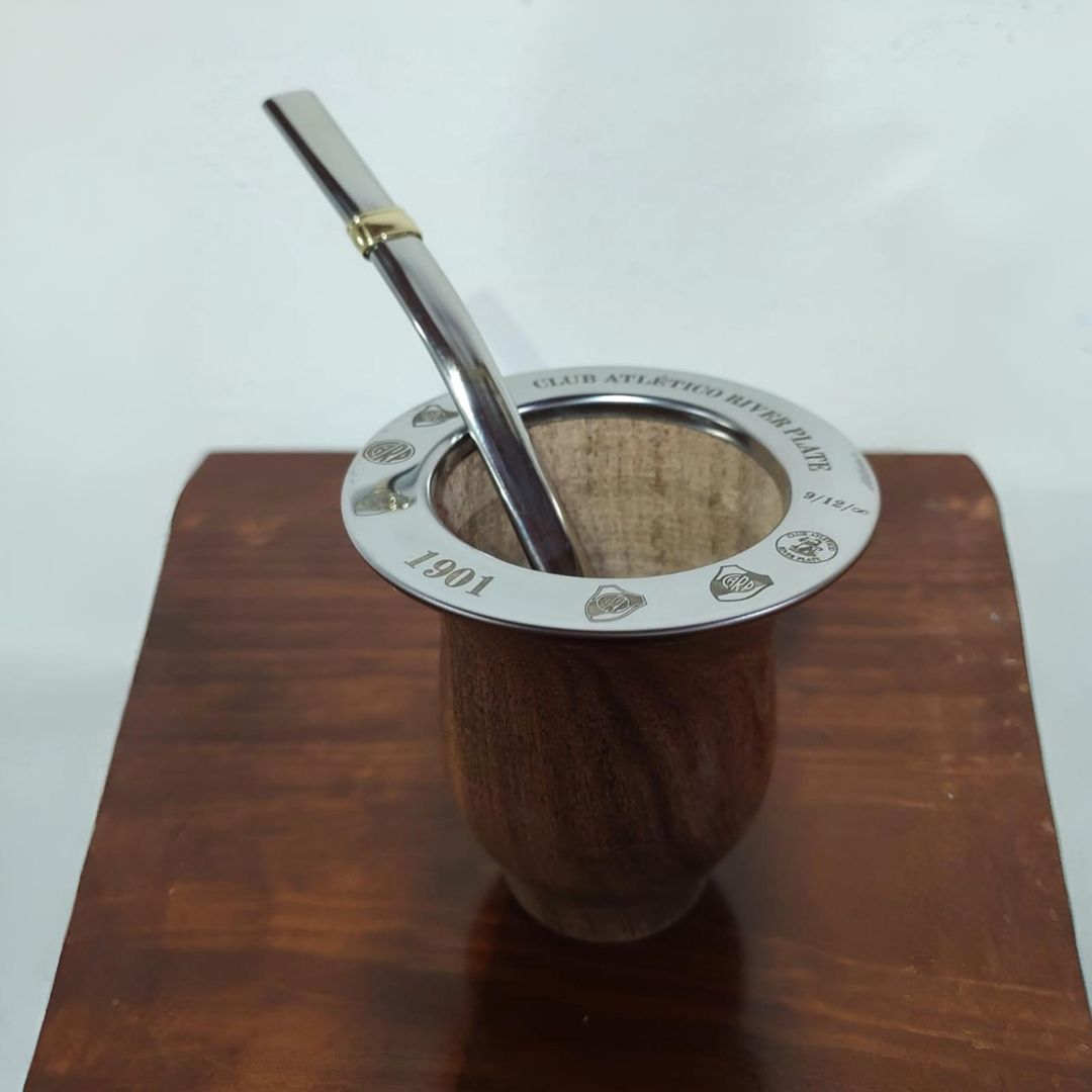 Matera de madera con borde plateado y bombilla sobre superficie de madera.