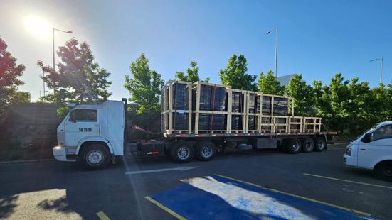 Un camión transporta cajas en un remolque en un estacionamiento.