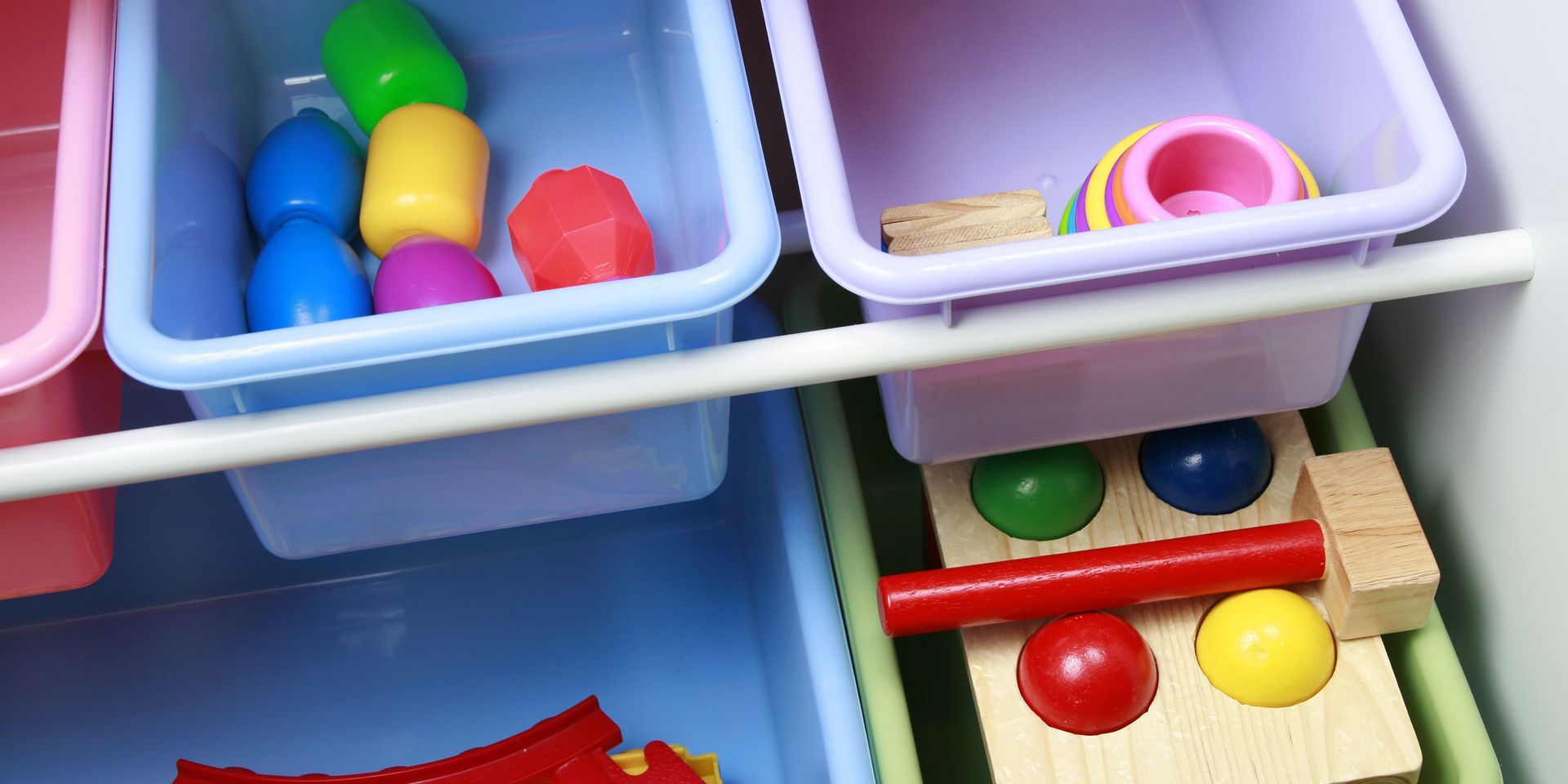 Colorful toys in storage bins of a kid's toy shelf.