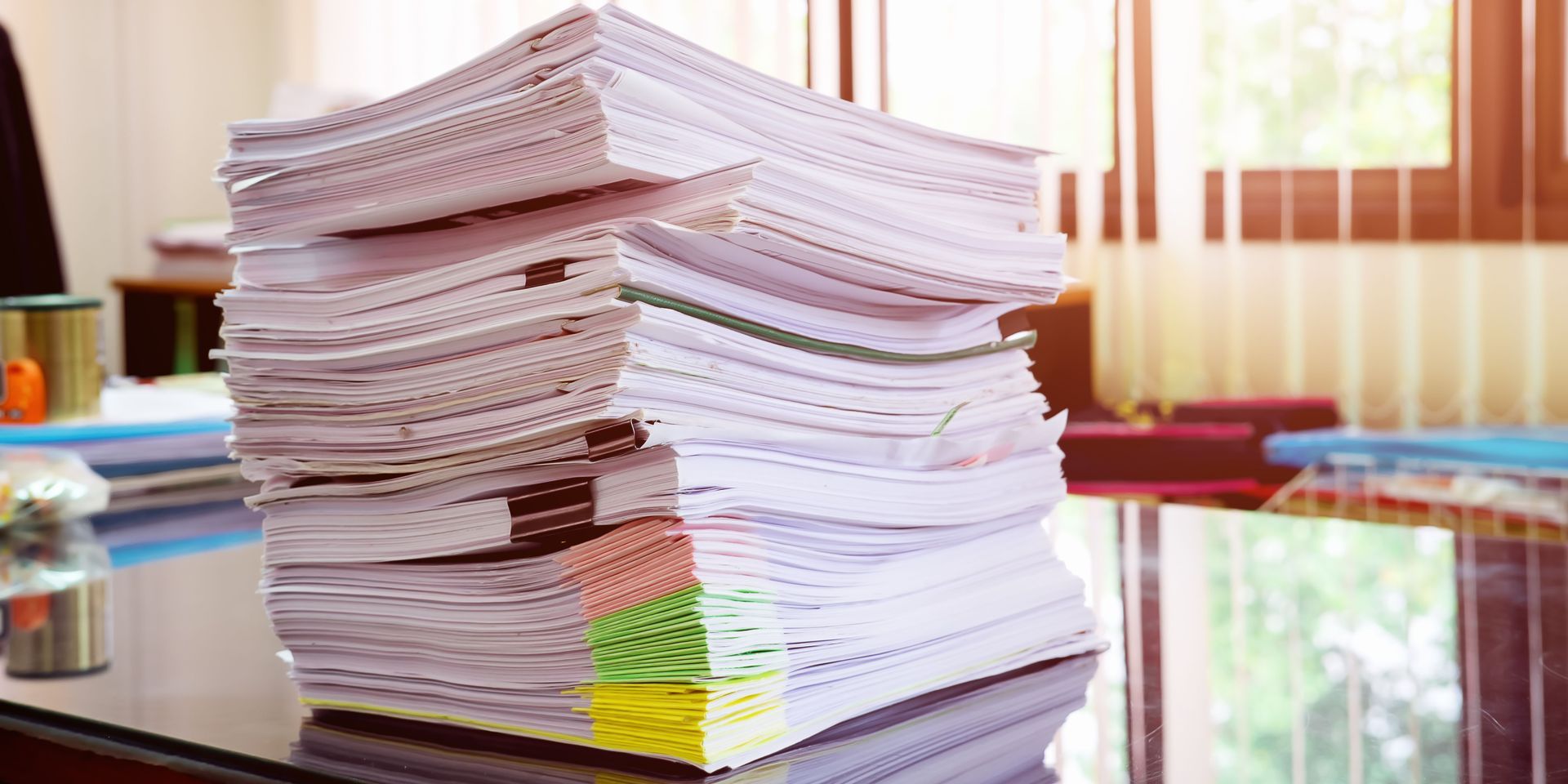 A stack of papers is sitting on top of a desk.