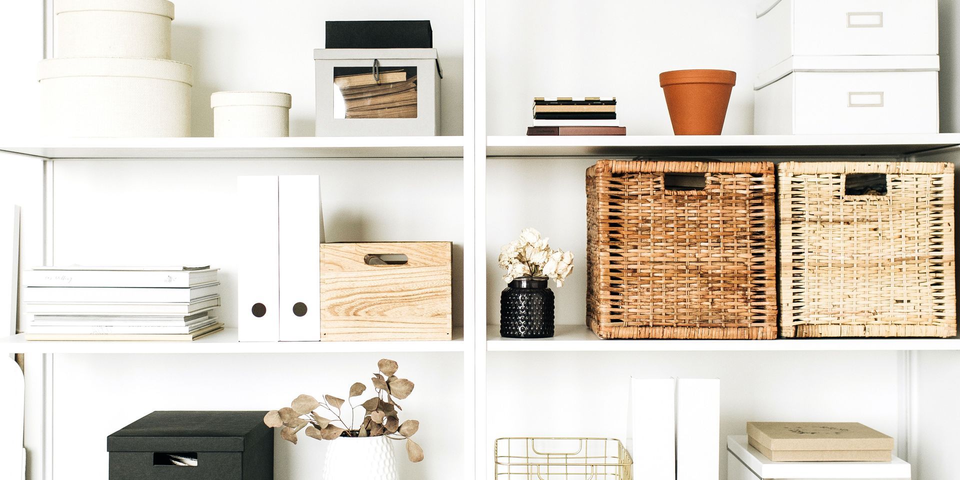 White shelves with various storage boxes, a pot, files, and decorative items.