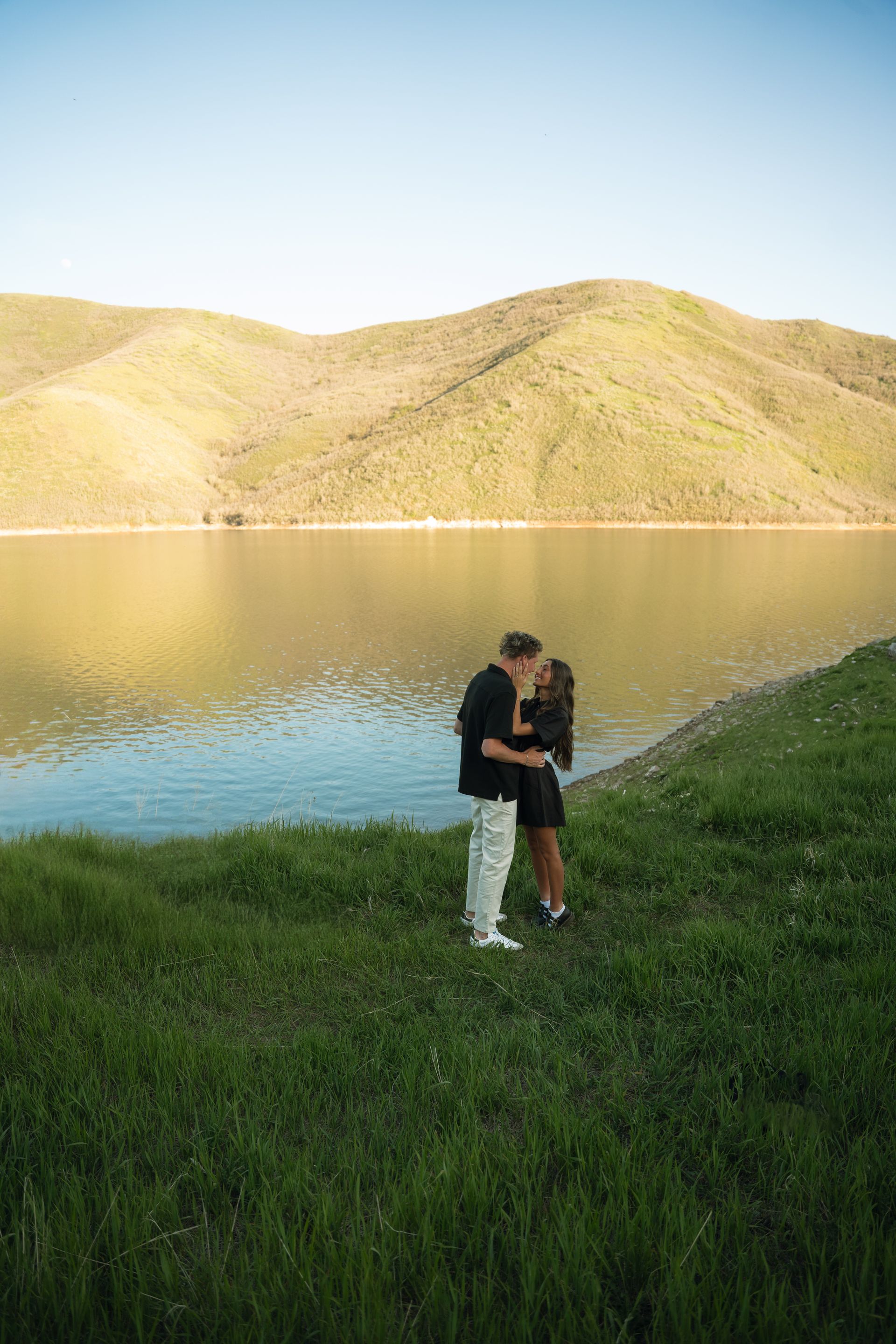 A woman in a white skirt is running in a field with a man in the background.
