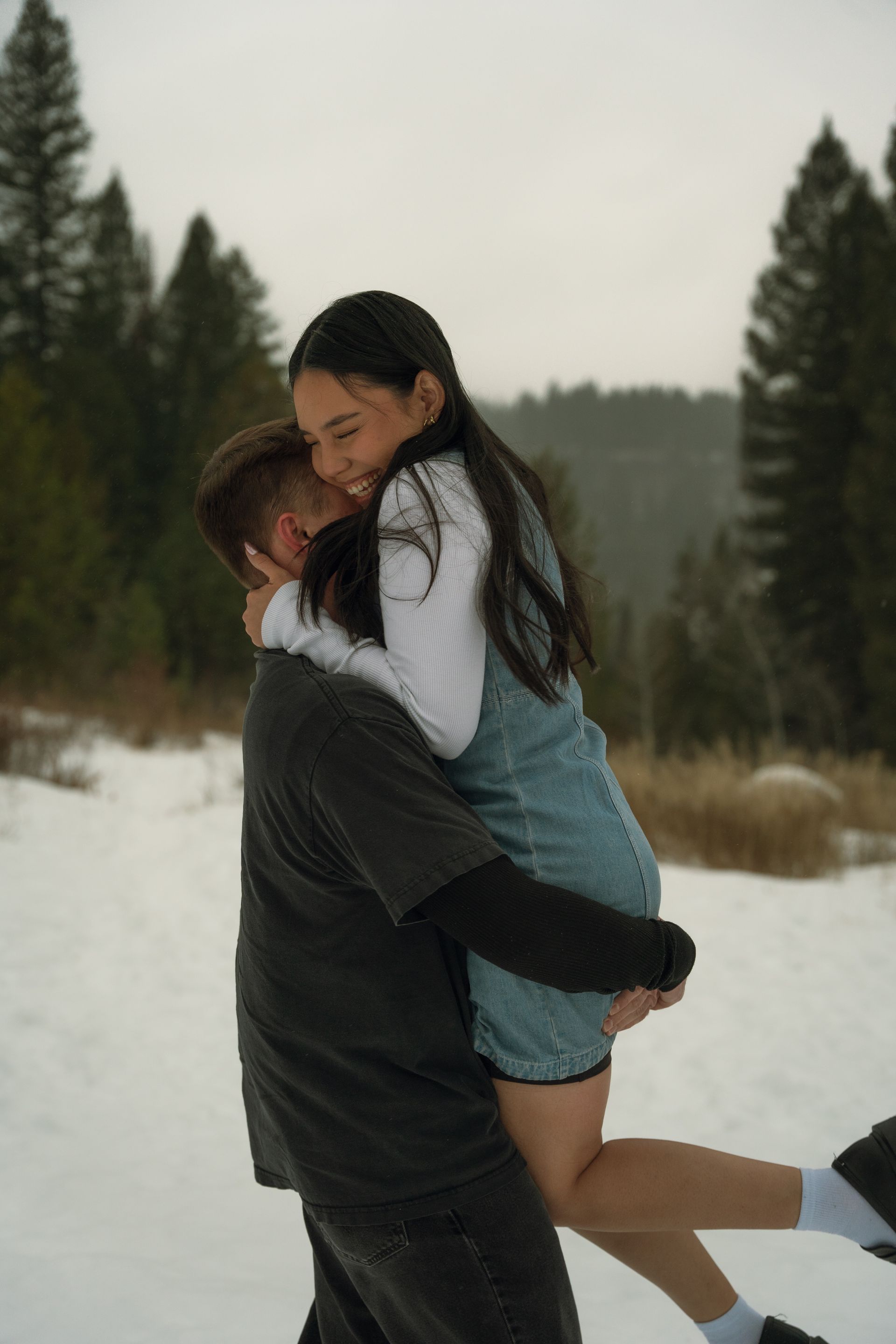 A man is carrying a woman in his arms in the snow.