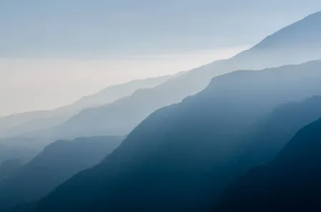 The mountains are covered in fog and the sky is clear.