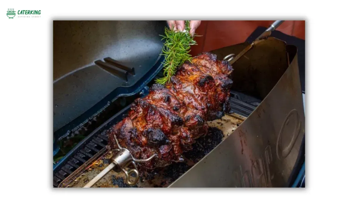 basting lamb with rosemary brush and olive oil during spit roasting
