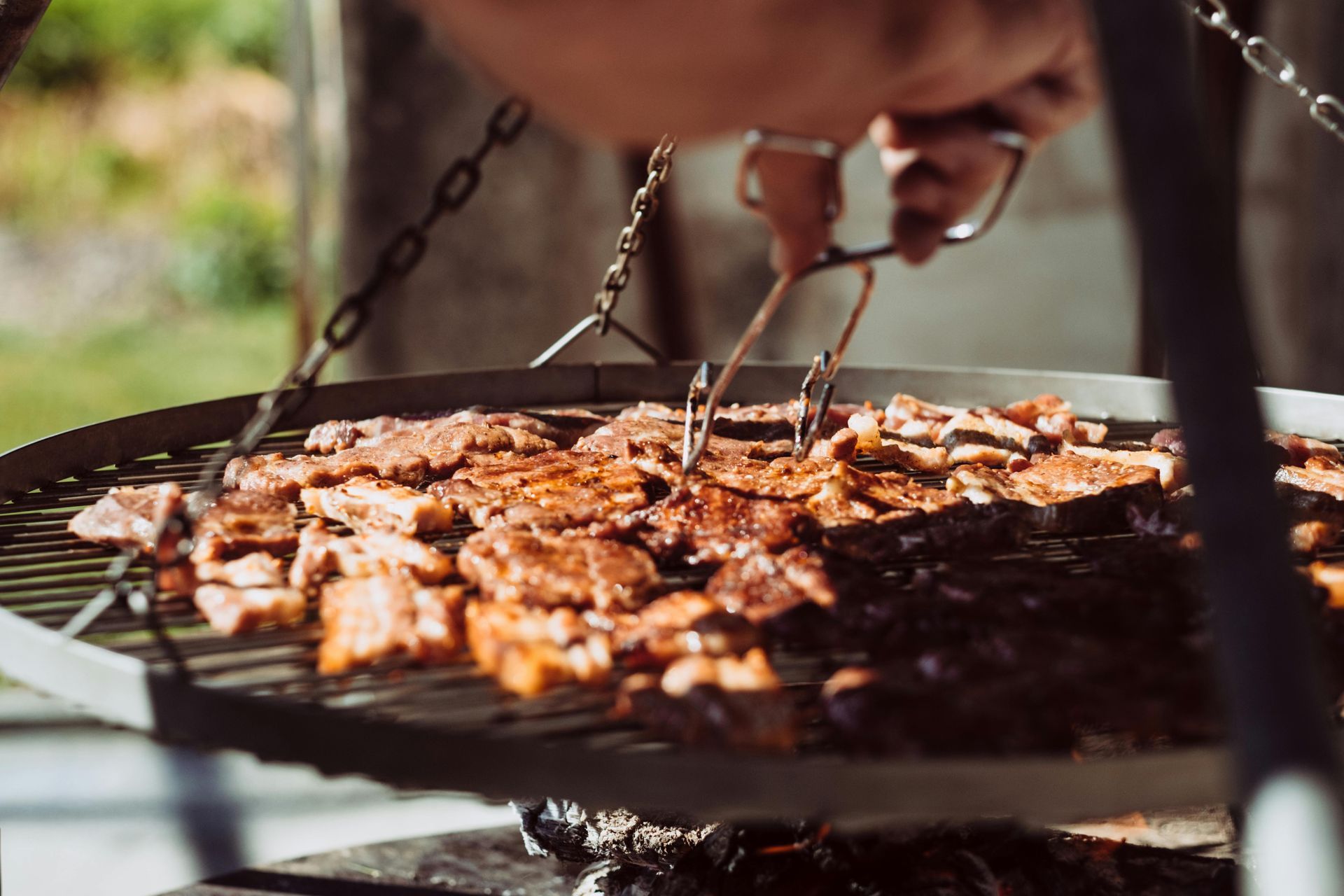 Grilled meat skewers on a smoking grill.