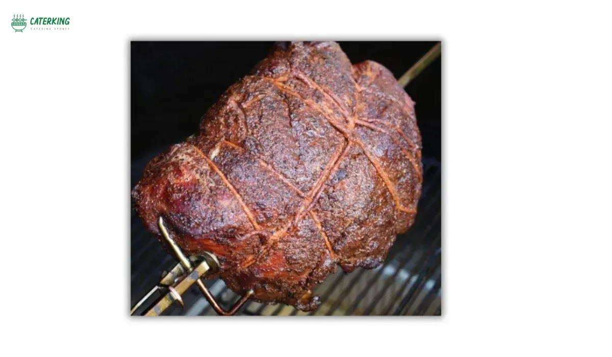 pork shoulder trussed and mounted on spit rod for even rotation
