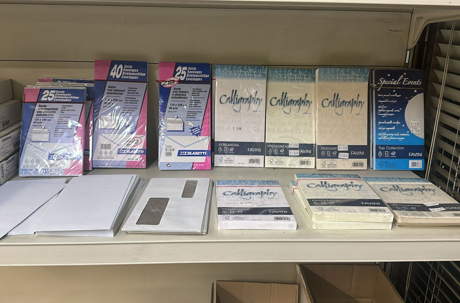 Scaffali pieni di carta per calligrafia, buste e cancelleria.