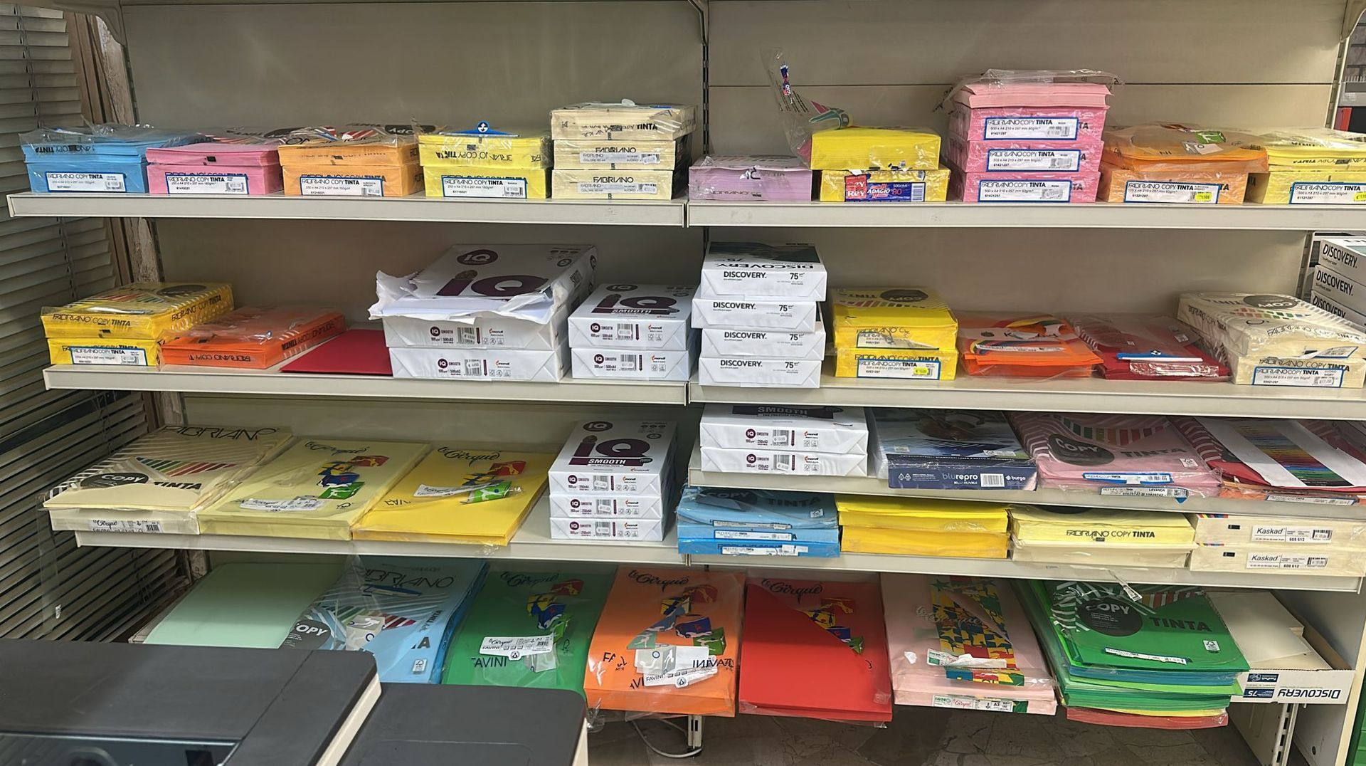 Scaffali pieni di scatole di carta colorate e blocchi in un negozio al dettaglio.