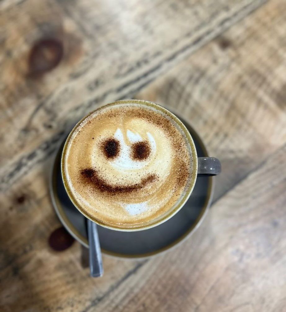 a cup of coffee with a smiley face drawn on the foam .