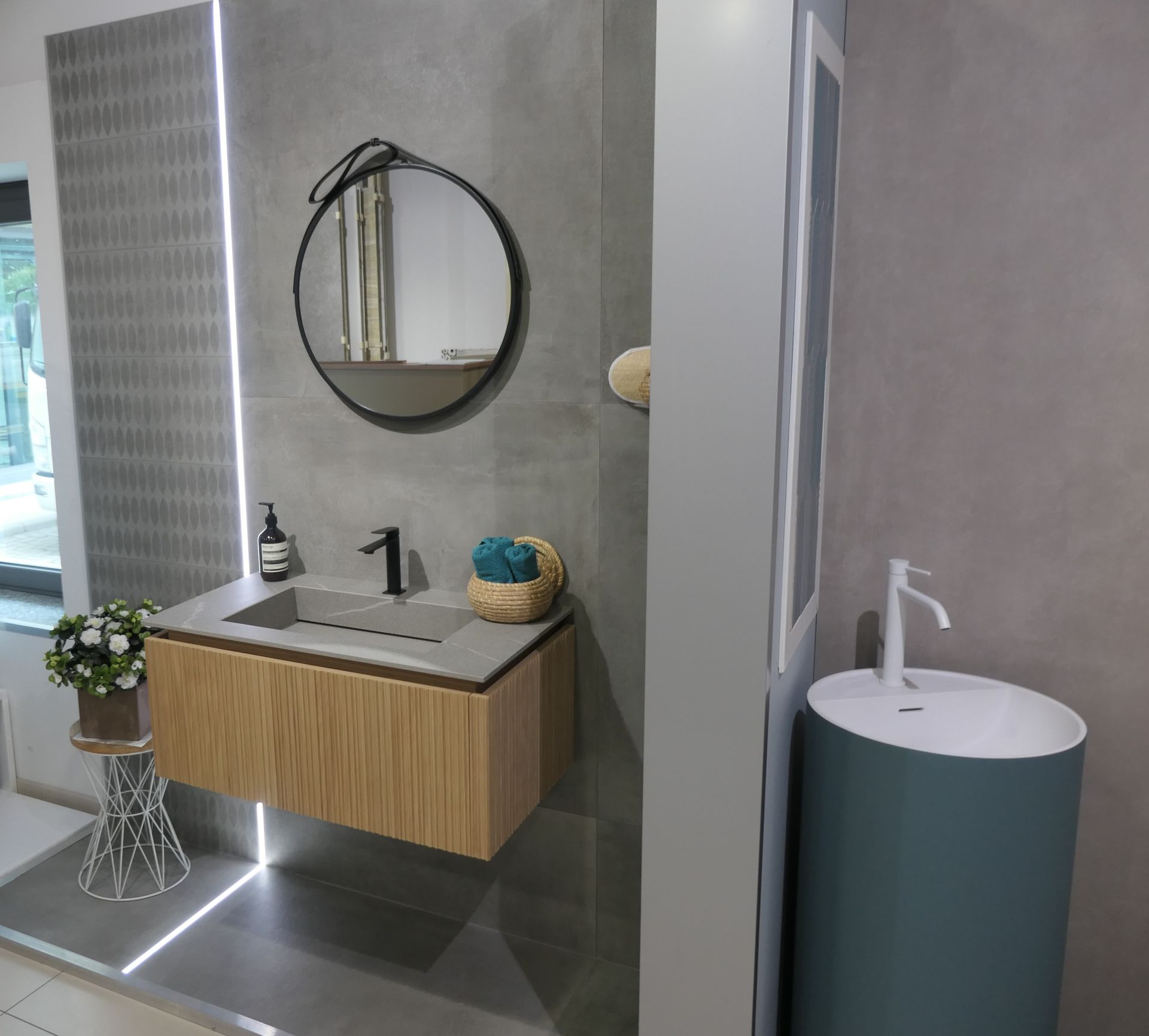 Specchio circolare e lavandini nello showroom a Novara