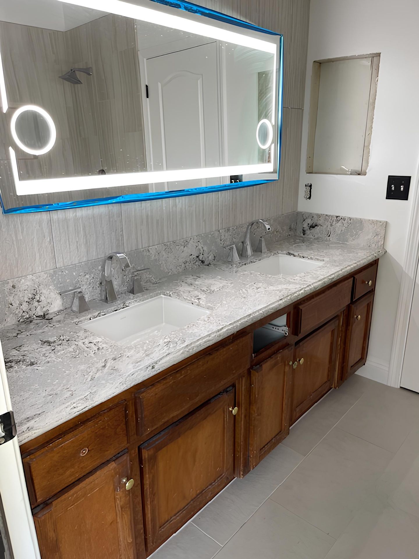 A bathroom with two sinks and a large mirror.