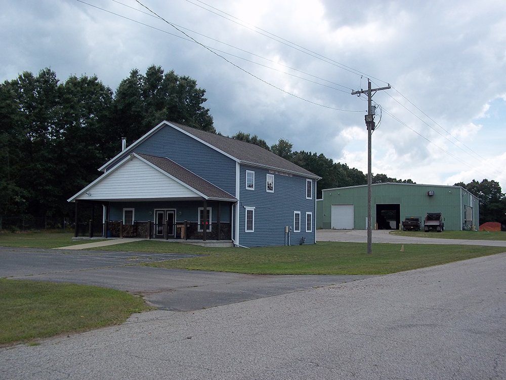 A house with a green warehouse at the back — Dowagiac, MI — Williams A-1 Expert Tree Service