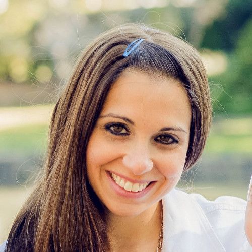 A woman with long brown hair is smiling for the camera