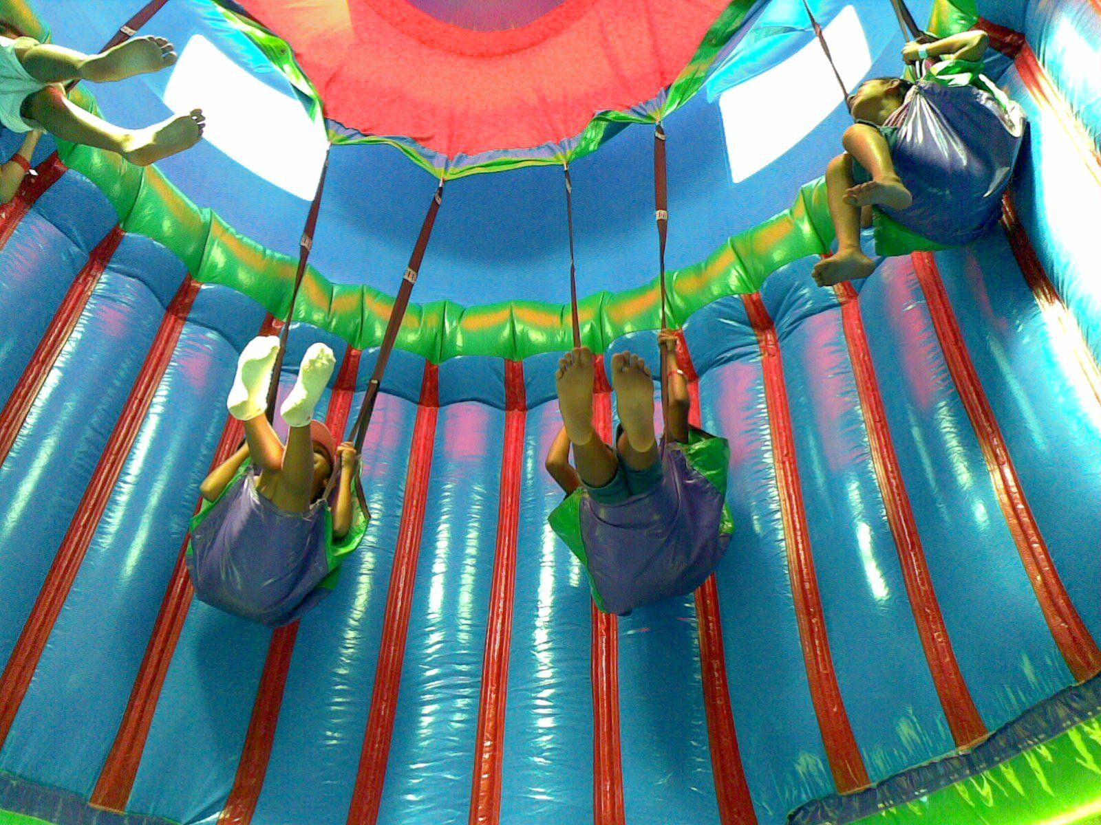 A group of people are riding a giant inflatable swing