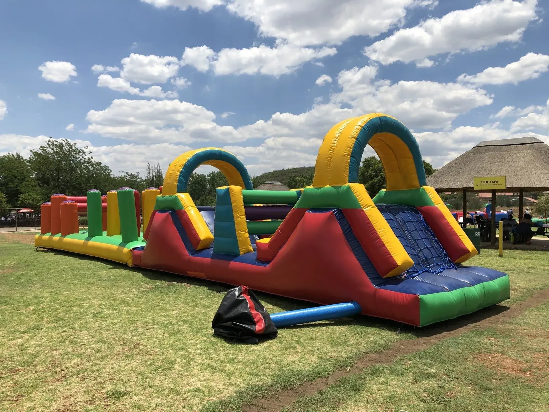 A large inflatable obstacle course is sitting on top of a lush green field.