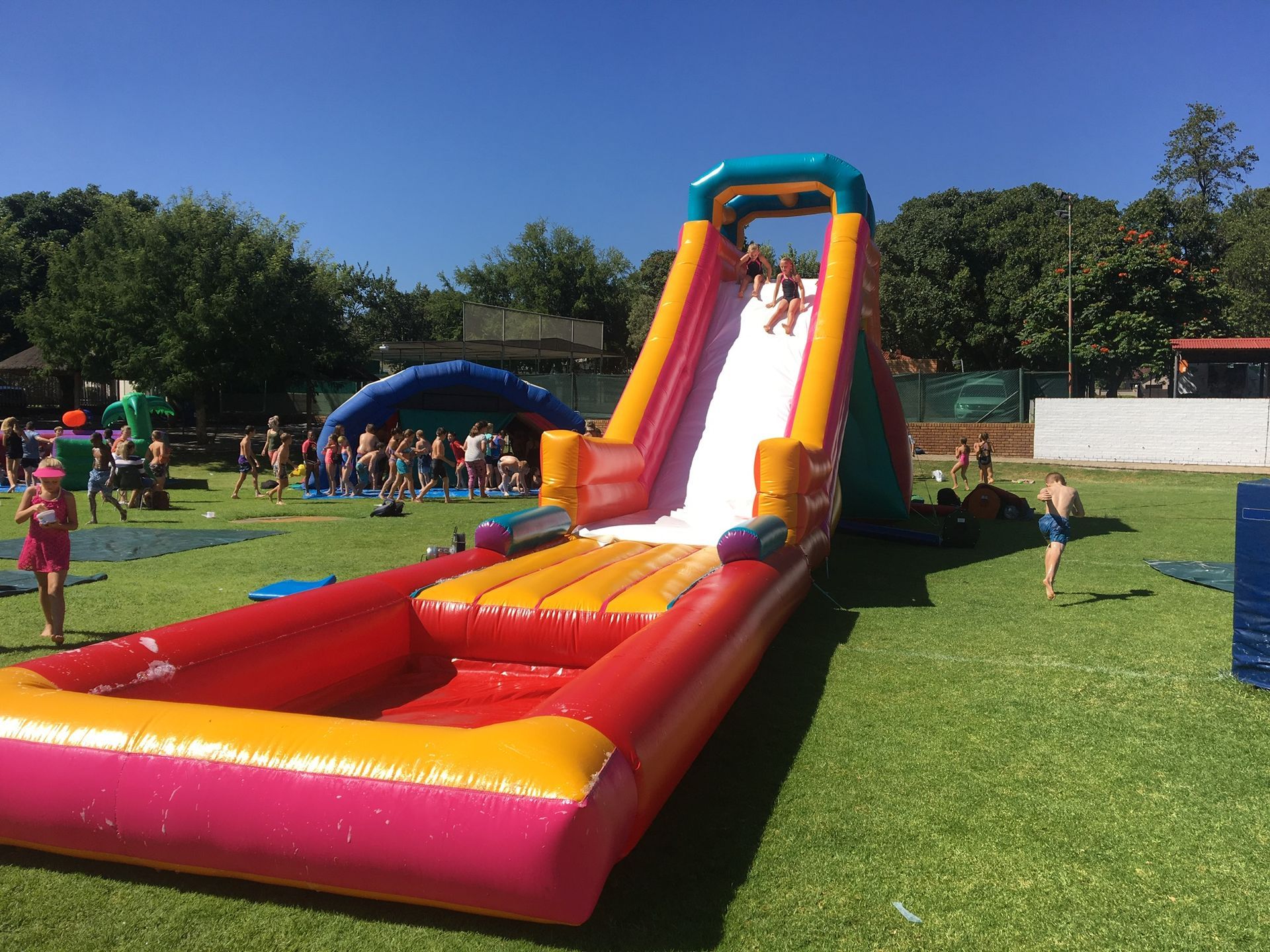 A group of people are playing on an inflatable water slide